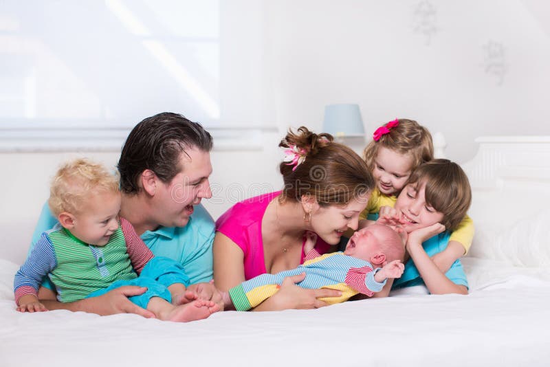 Stor familj med ungar i säng royaltyfri fotografi Stor familj med ungar i säng royaltyfri fotografi