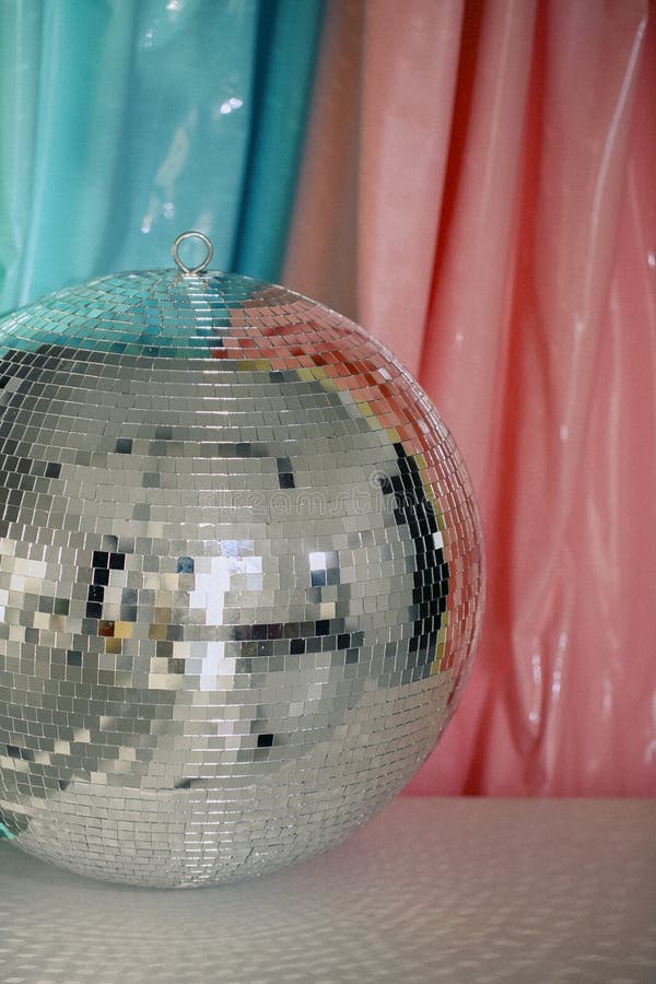Stor glansig reflekterande spegel, gnistrande nattlid-discoball mot färgbakgrund royaltyfri foto