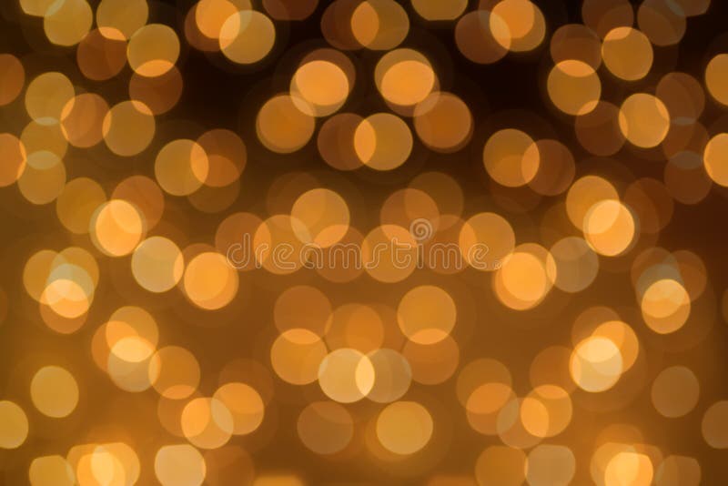 Big round Bokeh in golden yellow on dark brown background. Abstract Blurred circles background photo. Big round Bokeh in golden yellow on dark brown background. Abstract Blurred circles background photo