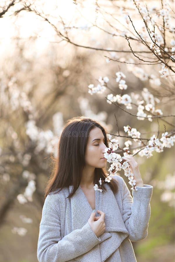 Storartad flicka i en blommande trädgård arkivfoto