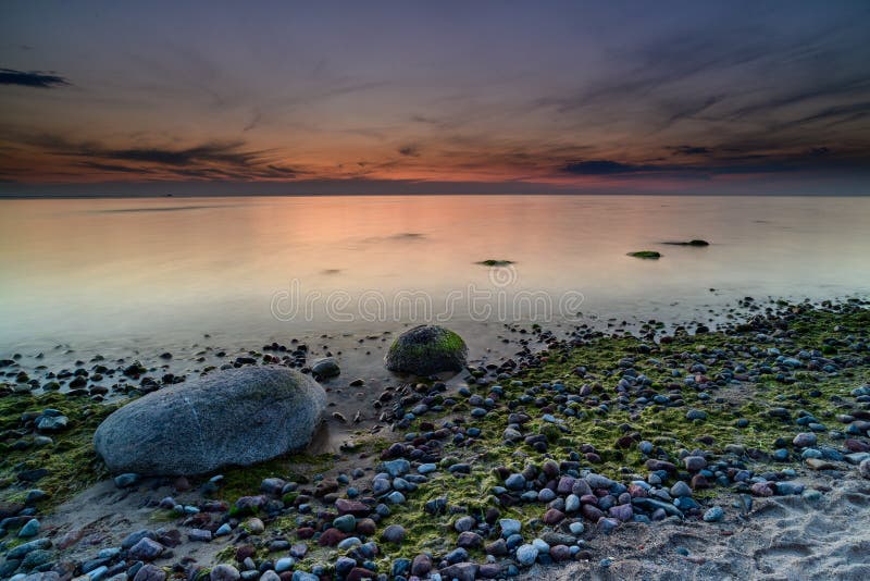 Storartad seascape på solnedgången med stenar täckte havsväxter fotografering för bildbyråer Storartad seascape på solnedgången med stenar täckte havsväxter fotografering för bildbyråer