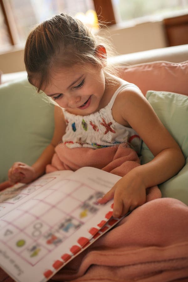 Storia della lettura della bambina a casa immagini stock Storia della lettura della bambina a casa immagini stock