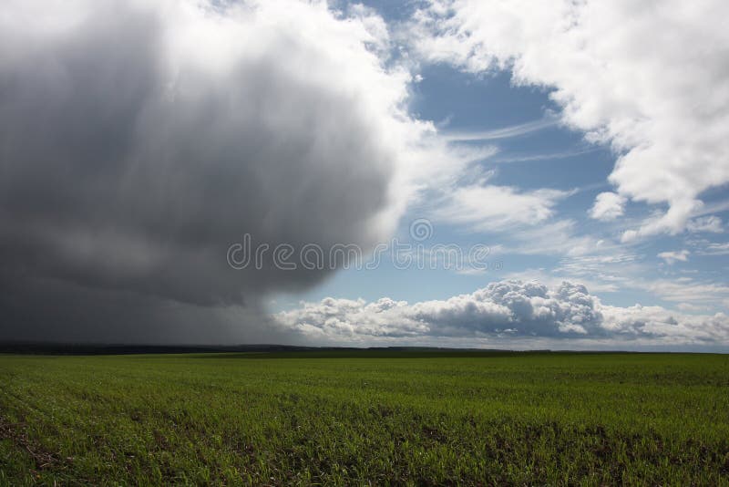 Storm cloud over green field