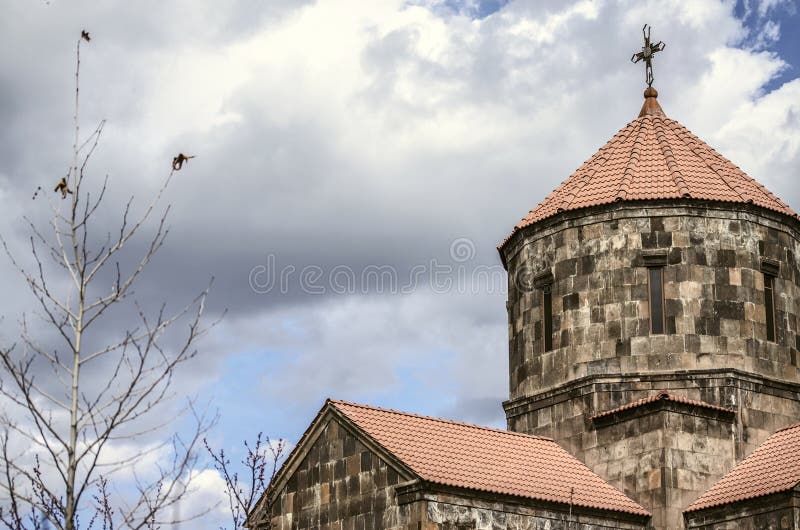 Storm clouds over the dome in the form of an umbrella covered with red tiles with forged cross in the Church of the Holy Cross in. Yerevan; Armenia; the royalty free stock photos Storm clouds over the dome in the form of an umbrella covered with red tiles with forged cross in the Church of the Holy Cross in. Yerevan; Armenia; the royalty free stock photos