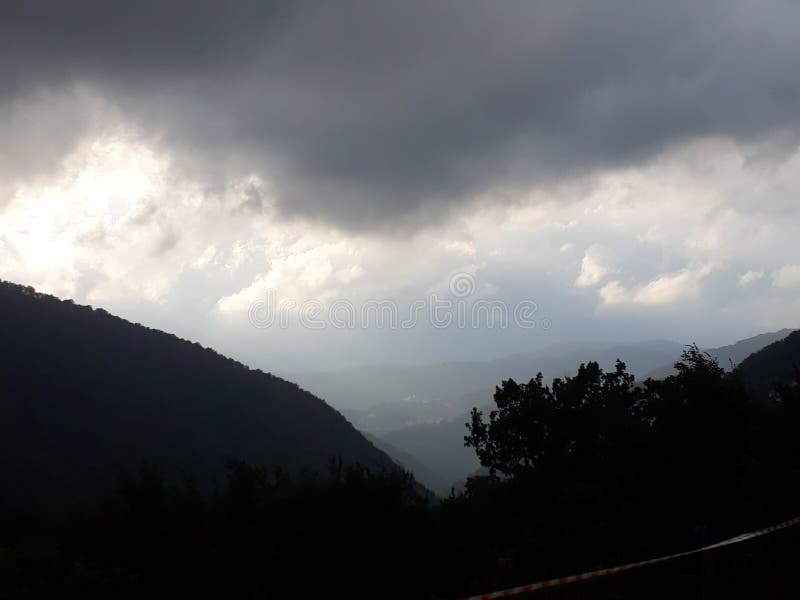 Foe, Genoa, Italy. Storm on the mountains, dark clouds in the sky. Rainy day, the sun desappears. Country landscape, hostile weather. Foe, Genoa, Italy. Storm on the mountains, dark clouds in the sky. Rainy day, the sun desappears. Country landscape, hostile weather.