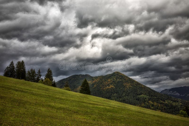 Stormy clouds on sky and hill at background. Autumn country