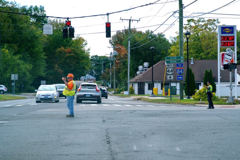 Construction worker aiding state trooper directing traffic