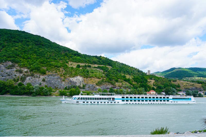 Stort kryssningskepp på Danube River och berg i bakgrund arkivbild