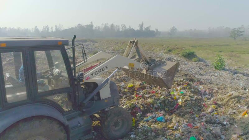 Storten van afval met behulp van jcb - machine in de installatie voor het beheer van vaste afvalstoffen.