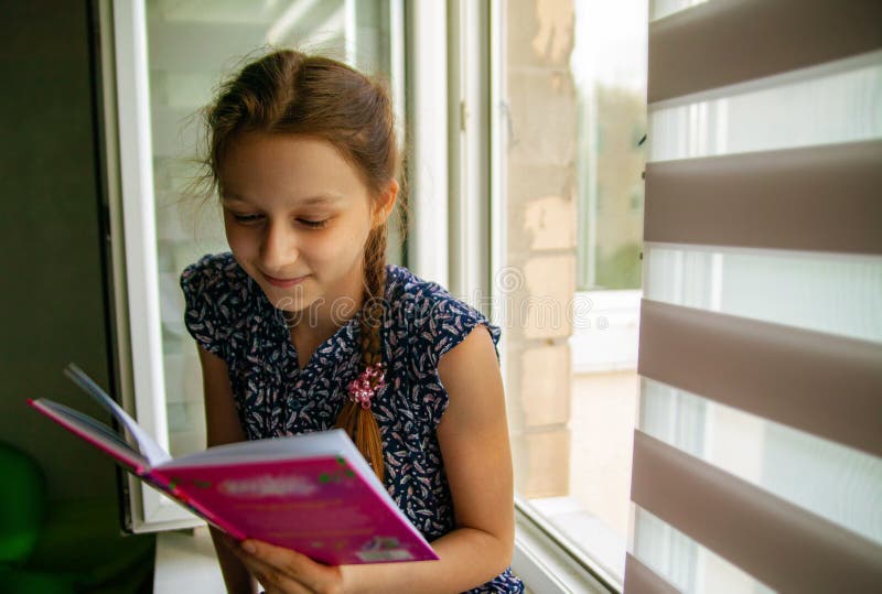 Adorable little girl reading a book in her home. stock photos Adorable little girl reading a book in her home. stock photos