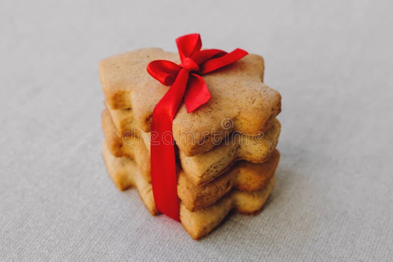 Stos ciastek chleba krótkiego w kształcie choinki z piękną czerwoną wstążką Słodki prezent obraz stock Stos ciastek chleba krótkiego w kształcie choinki z piękną czerwoną wstążką Słodki prezent obraz stock