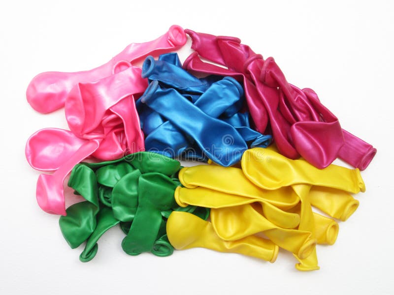 Pile of uninflated balloons from different colors. White isolated. Pile of uninflated balloons from different colors. White isolated