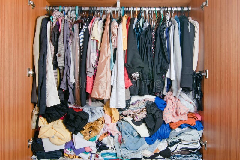 Stos upaćkany odziewa w szafie Nieporządna cluttered kobiety garderoba