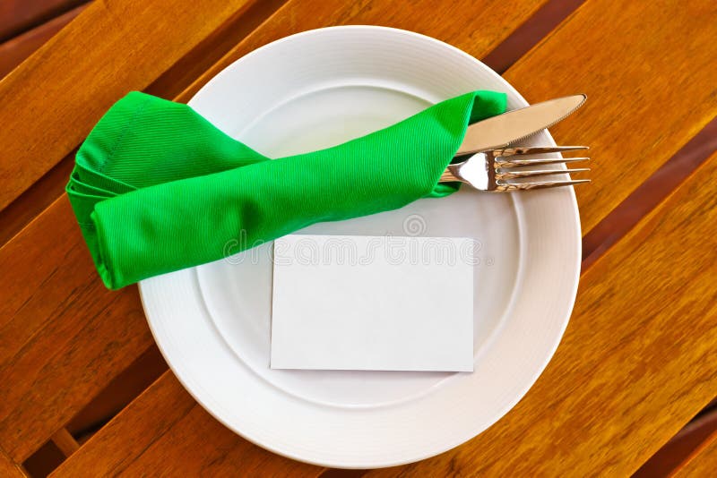 Stoviglie e carta di carta in bianco sulla tavola in ristorante immagini stock libere da diritti Stoviglie e carta di carta in bianco sulla tavola in ristorante immagini stock libere da diritti