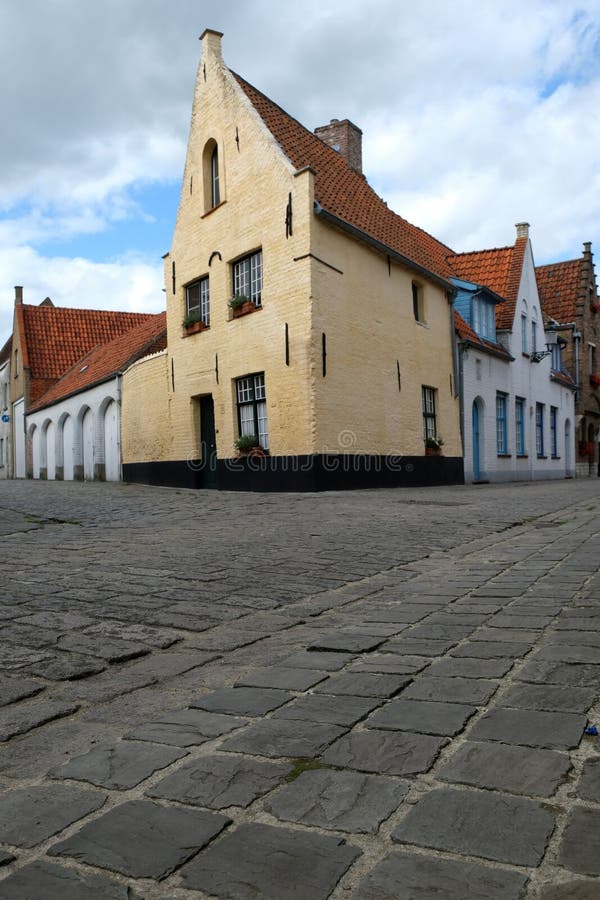 Straatscène in Brugge/Brugge, België met het gele huis en kei bedekken royalty-vrije stock afbeeldingen Straatscène in Brugge/Brugge, België met het gele huis en kei bedekken royalty-vrije stock afbeeldingen