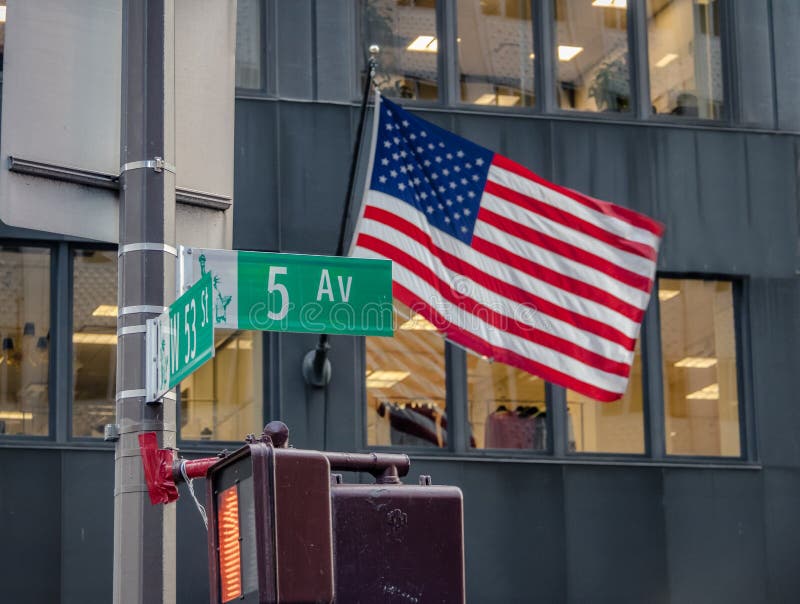 Straatteken van Vijfde Ave met Amerikaanse Vlag als achtergrond - New York, de V.S.