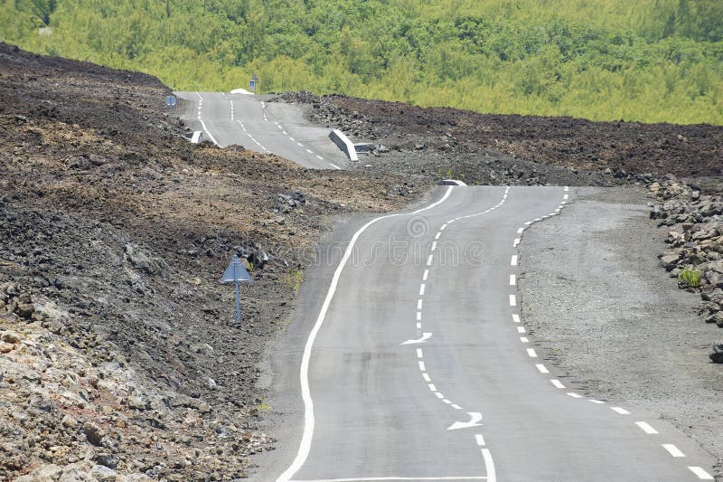 Strada asfaltata curva sopra lava vulcanica, Reunion Island, Francia fotografie stock Strada asfaltata curva sopra lava vulcanica, Reunion Island, Francia fotografie stock