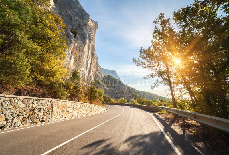 Strada asfaltata nella foresta di autunno ad alba Montagne della Crimea fotografie stock libere da diritti Strada asfaltata nella foresta di autunno ad alba Montagne della Crimea fotografie stock libere da diritti