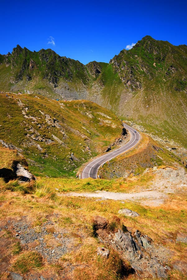 Road winding through rugged mountainous countryside on a clear, sunny day...shot in Romania at Fagaras Mountain. Road winding through rugged mountainous countryside on a clear, sunny day...shot in Romania at Fagaras Mountain.