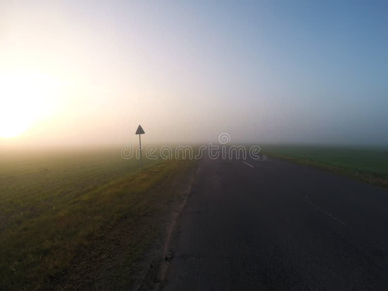 Strada nebbiosa all'alba, nebbia spessa, immagini stock libere da diritti Strada nebbiosa all'alba, nebbia spessa, immagini stock libere da diritti