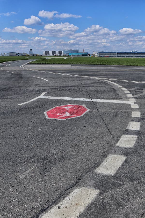 Ground traffic airport sign to stop and give priority to planes with airport buildings. Ground traffic airport sign to stop and give priority to planes with airport buildings