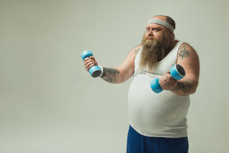 Strained fat man exercising with sports equipment stock images Strained fat man exercising with sports equipment stock images
