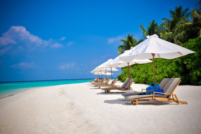 Shezlongs on Maldives beach blue sky. Shezlongs on Maldives beach blue sky