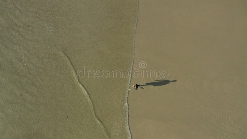 Strand- und Surfsportler, die zum Surfen oder Training in der Natur zu Wasser laufen. Luft und männliche