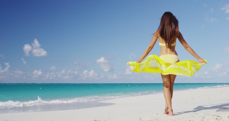 Strandmädchen mit pareo im Wind glücklich und frei über Strandferien