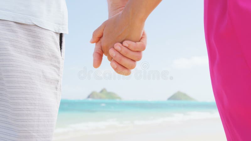 Strandpaare im Liebeshändchenhalten auf Flitterwochen