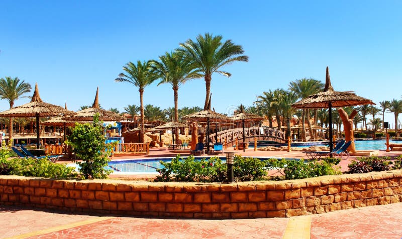Strandparaplu's en sunbeds op de pool stock afbeelding Strandparaplu's en sunbeds op de pool stock afbeelding