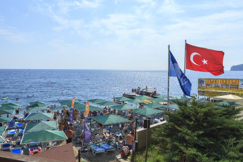 Strandschirme und türkische Flagge am Erholungsort in Kemer lizenzfreies stockfoto Strandschirme und türkische Flagge am Erholungsort in Kemer lizenzfreies stockfoto