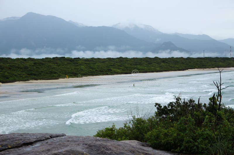 Strandsikter av fastlandet med vågor, skogen, moln och berg arkivbild Strandsikter av fastlandet med vågor, skogen, moln och berg arkivbild