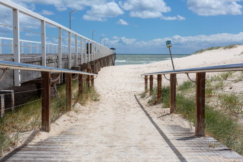 Strandtillträdesrampen längs sidan av lantgårdbryggan med en blått royaltyfri foto Strandtillträdesrampen längs sidan av lantgårdbryggan med en blått royaltyfri foto