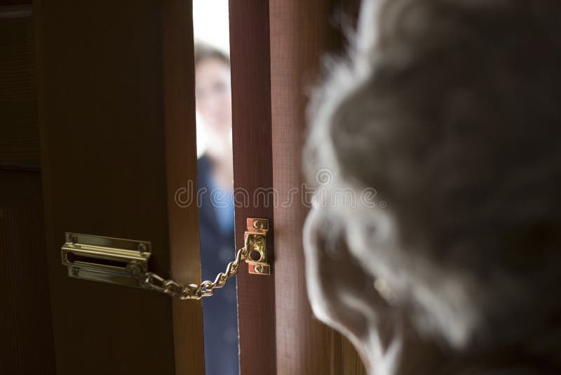 Senior donna con una catena di sicurezza su porta anteriore