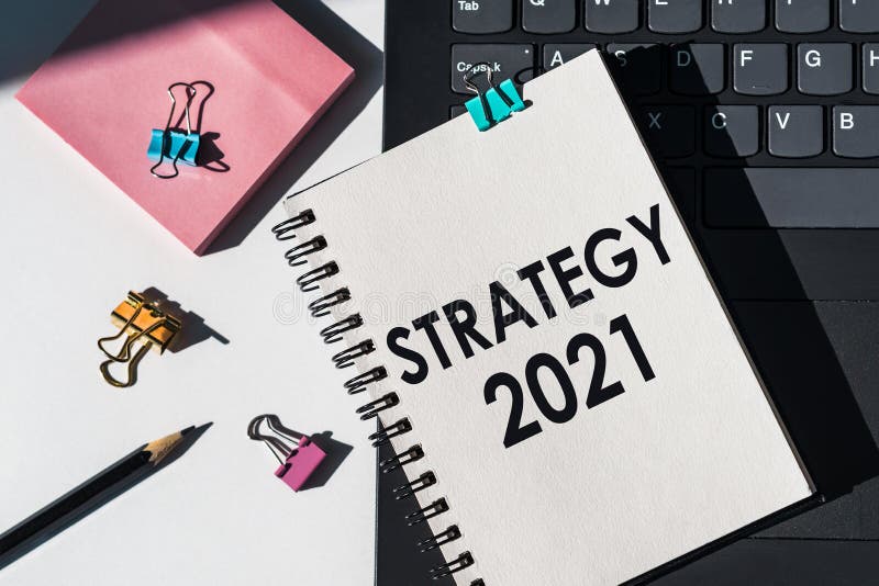 Strategia 2021 tekst napisany w notebooku jest oparty na laptopie z materiałami biurowymi. perspektywiczne podejście do osiągnięci zdjęcie stock