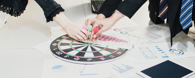 strategy and goal concept, group of business people put arrow on dart board to aim and success, team work and vision