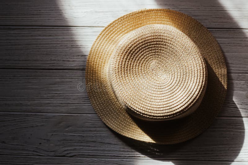 Straw Beach Hat with Brims for Sun Protection on Wooden Boards. Stock
