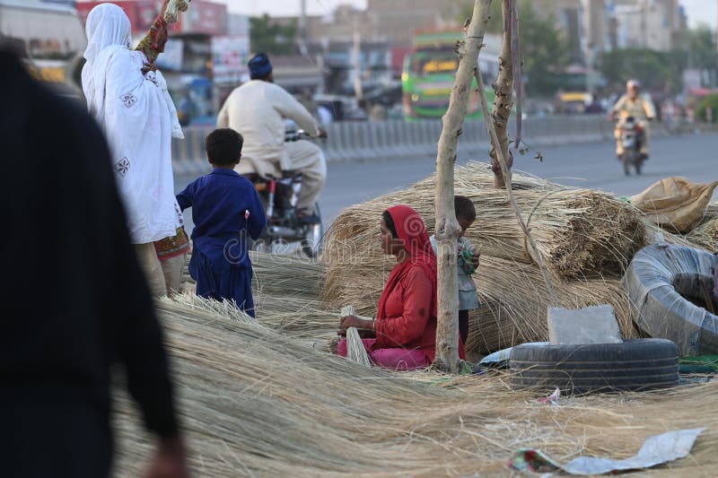 A straw broom Sellers are making broom with straws in rural areas of Punjab stock photography