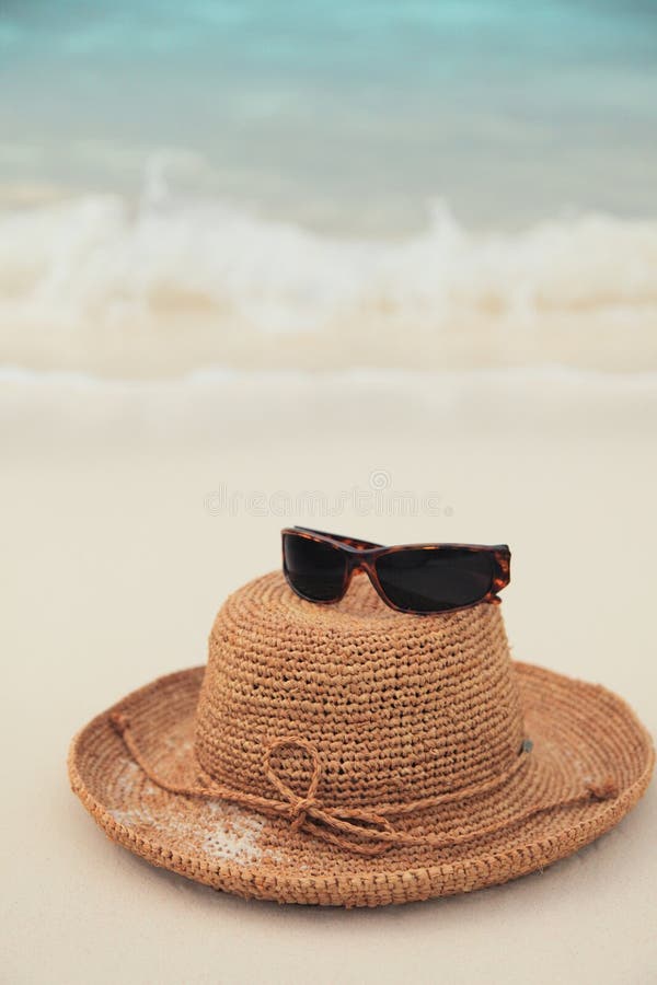 Straw hat and sunglasses on tropical island