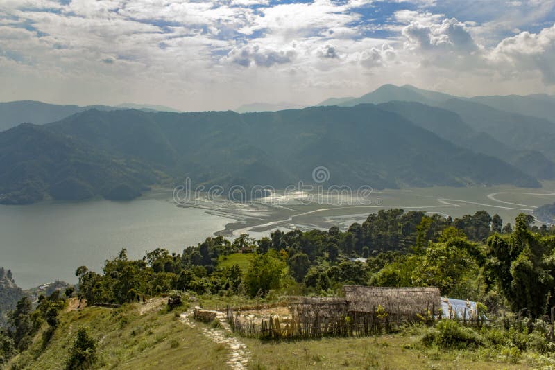 Straw hut on a hillside against the backdrop of a green mountain valley with a lake stock images Straw hut on a hillside against the backdrop of a green mountain valley with a lake stock images
