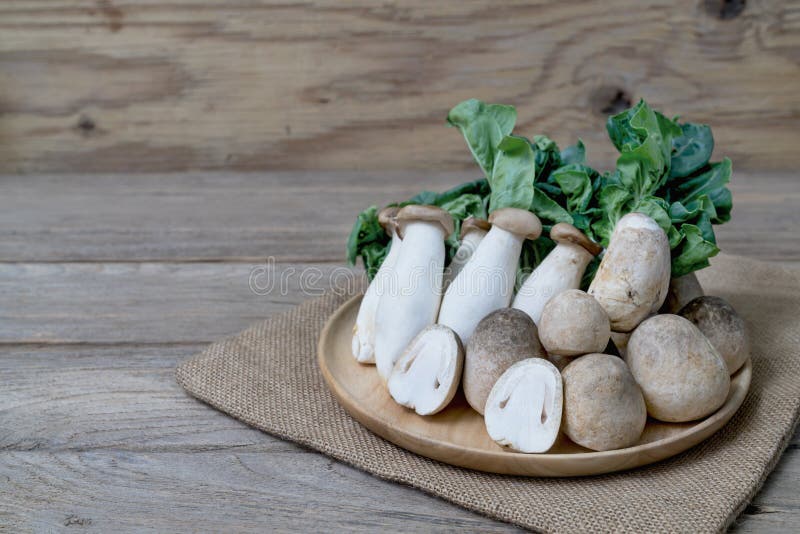 Straw mushroom and king oyster mushrooms on wooden table royalty free stock photo