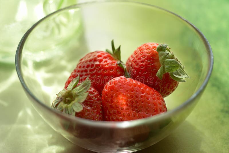 Strawberries in aglass bowl with reflections