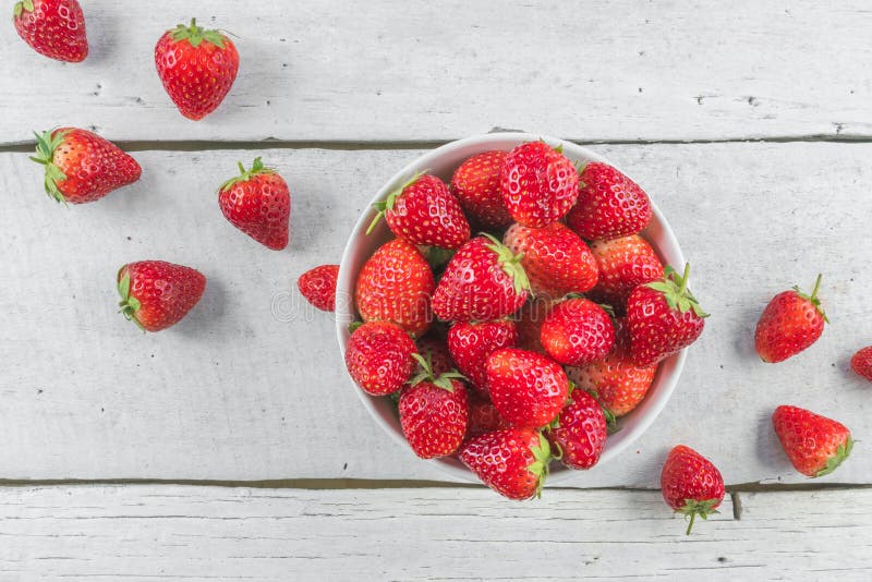 Strawberries in bowl on white table top view