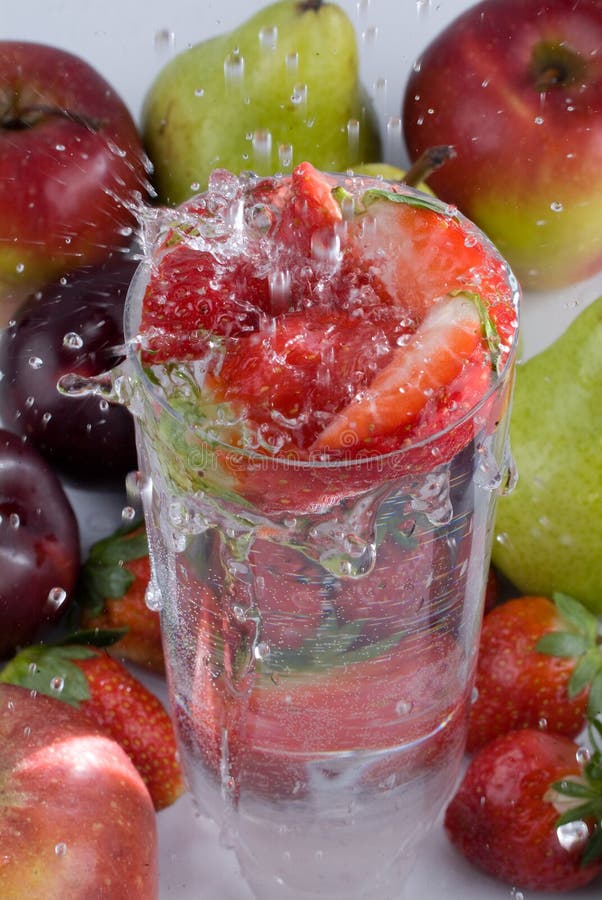 Strawberries falling in glass of water