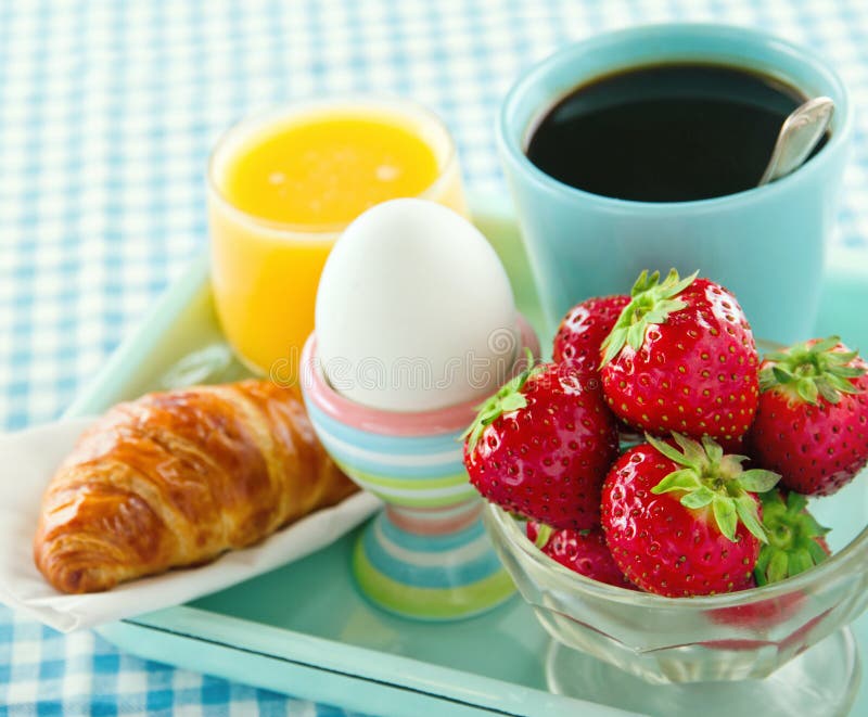 Strawberries, juice, croissant and coffee for breakfast