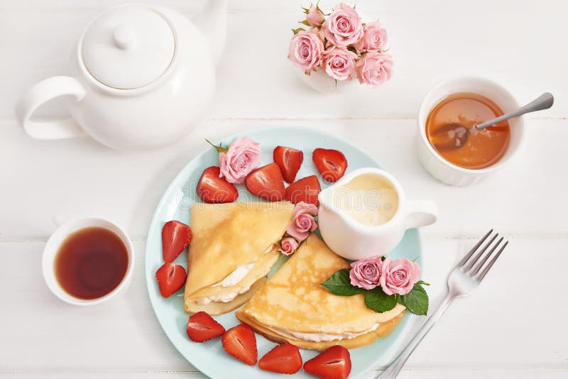 Strawberries and pancakes. Pancakes with strawberries. Romantic breakfast. Valentine`s Day. Greeting Card Mother`s Day. Breakfas