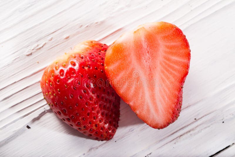 The Strawberry Berry Cut In Half On A White Board Stock Photo Image