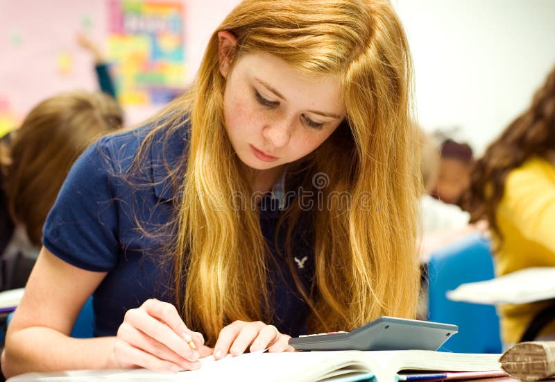 Strawberry blonde teenage girl doing math work