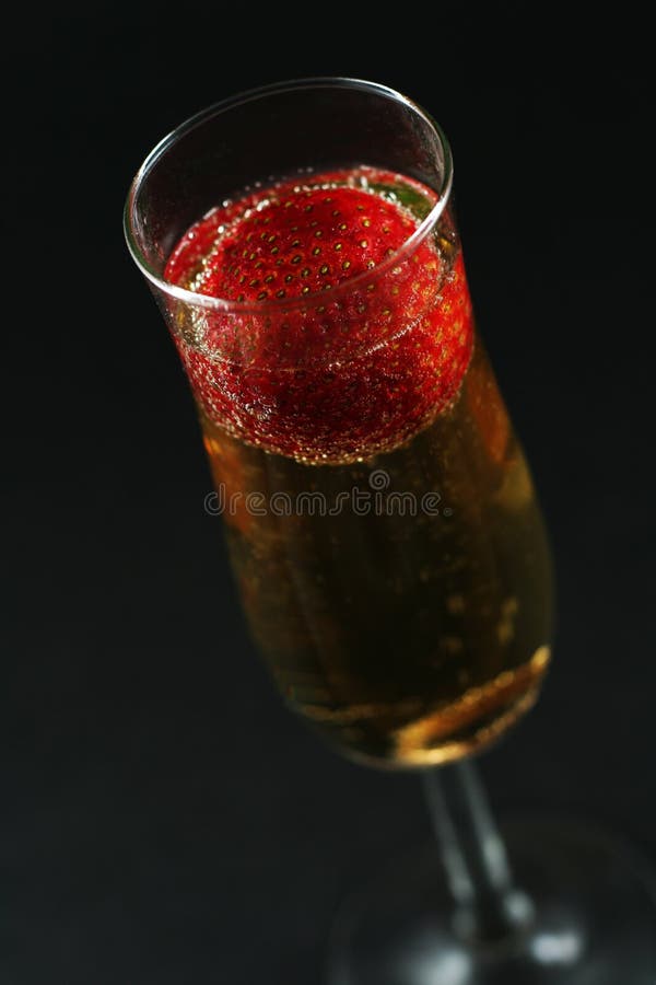 Strawberry in champagne against dark background